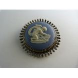 Wedgwood silver set brooch depicting cupid sharpening his arrows on a stone. 40mm in diameter