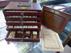 A Mahjong set with rule book, tiles etc in a wooden brass bound carry case