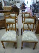 A set of four Arts and Crafts oak chairs with humped carved rail, vertical shaped splats leading