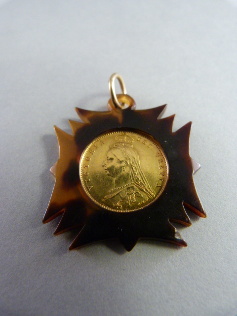 An 1887 Victorian Half Sovereign in good condition mounted on Tortoise shell surround to form a