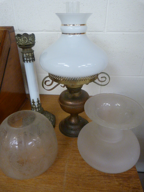 Tall gilt oil lamp with floral decoration to base, above long glass stem leading to a frosted
