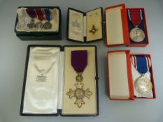 OBE Medals in boxes with OBE certificates