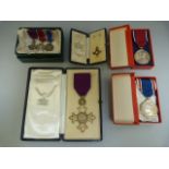 OBE Medals in boxes with OBE certificates