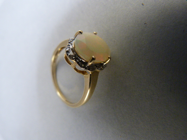 9ct Yellow Gold milky opal and diamond ring. The oval opal measures approx 10mm x 8mm with subtle - Image 3 of 6