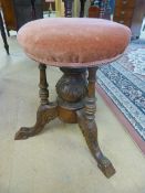 Revolving mahogany piano stool with three turned wooden supports leading down to a baluster base