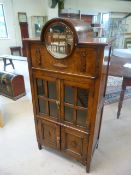 Unusual oak cabinet with circular mirror front and cupboard under