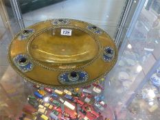 A bronze Arts and Crafts Tazza set with six dark coloured cabochons and each in a raised decorated