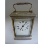 Brass cased carriage clock with 5 panels of bevelled glass. The chapters are Roman Numerals on a