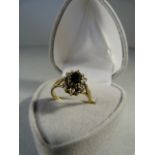 Sapphire and Diamond cluster ring set in 9ct Gold. Oval Approx 5.80mm x 4.1mm dark sapphire centre