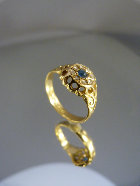 18ct Gold ring with central Sapphire gemstone and surrounded by a circle of diamonds