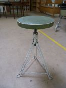 Factory metal mid century stool on tripod base and with a green leather seat