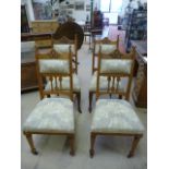 A set of four Arts and Crafts oak chairs with humped carved rail, vertical shaped splats leading