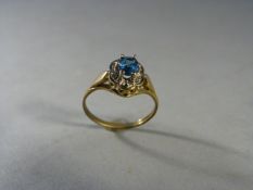 Blue Topaz and diamond cluster ring set in 9ct Gold. The oval Topaz in approx 5.26mm x 3.92mm with 4