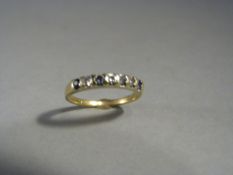 Sapphire and Diamond half hoop eternity ring. Set with 4 small pale blue sapphires and 4 small 8 cut