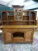 A Shapland and Petter unusual Arts and Crafts dresser in Golden Oak fitted with stylised foliate