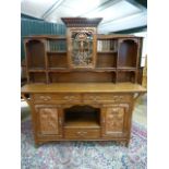 A Shapland and Petter unusual Arts and Crafts dresser in Golden Oak fitted with stylised foliate