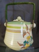 Clarice Cliff biscuit barrell with cover and rafia handle. Green banding to lid and rim wih