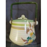 Clarice Cliff biscuit barrell with cover and rafia handle. Green banding to lid and rim wih