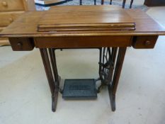 Singer sewing machine on cast iron stand and mahogany frame