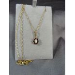 9ct Necklace set with hanging 'flower' pendant of ruby and 1 singular opal to middle.
