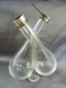 Double oil and vinegar glass pourer with silver collar and lid - one lid missing. Hallmarked