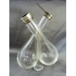Double oil and vinegar glass pourer with silver collar and lid - one lid missing. Hallmarked