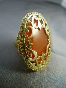 1980’s 14ct Gold Chinese Orange Jade ring. The approx. size: 30mm x 20mm oval stone is ‘trapped’