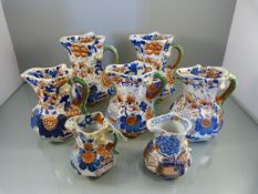 Seven 'Mason's Patent Ironstone china' graduated handpainted hydra jugs of octagonal form. Painted