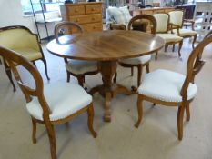 Walnut round pedestal table with tripod feet and four matching balloon back chairs.