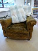 A Howard & Sons style club chair with deep low seat on oak legs with castors