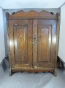 Small wooden cabinet of two doors, inside two small brass handled drawers - dated 25 December.