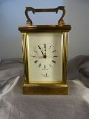 Brass cased carriage clock with five bevelled glass panels made by Fema, London 11 Jewels. White