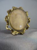 Pinchbeck mourning brooch/photo frame in the Nouveau style. Wave decoration round an ovular frame,