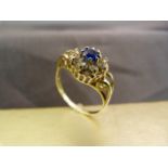 9ct Gold hallmarked dress ring with bright blue sapphire coloured stone surrounded by eight clear