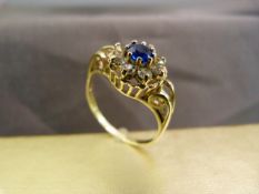 9ct Gold hallmarked dress ring with bright blue sapphire coloured stone surrounded by eight clear