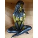 Metal figure of a scantily clad lady seated