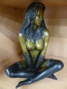 Metal figure of a scantily clad lady seated