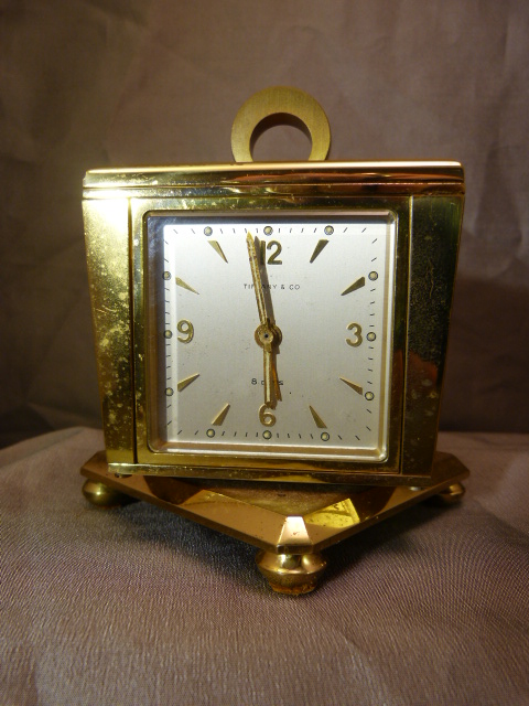 Tiffany and Co Brass eight day Desk clock on Rotating Art Deco base with circular handle. Four Faces