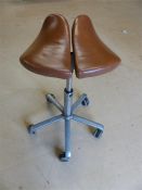 Salli Saddle seat / machinist stool - having an unusual saddle shaped seat in tan leather. Chrome