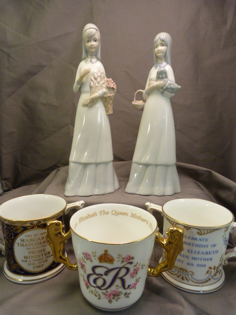 Pair of Lladro style figures of ladies, Two Royal Crown Derby - two handled cups commissioned by