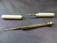 S Morden & Co Gold coloured toothpick with sliding action along with one other in a twisted bone