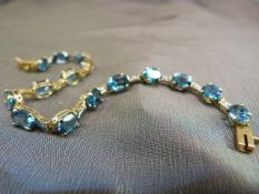 QVC 9ct Gold blue stone (Topaz) and diamond bracelet. There are 15 oval blue stones which are approc