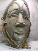 African carved mask with copper rope twist wire decoration inset to eyes, ears and forehead. Slitted