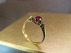 18ct Yellow Gold ruby and diamond ring. Set with single large ruby to centre and two diamonds