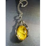 Arts and Crafts Silver necklace set with large oval Amber stone.