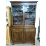 Mahogany 19th century bookcase with cupboards under, shaped frieze decoration sits above two