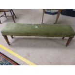 Long low green upholstered window seat on Sheraton style legs