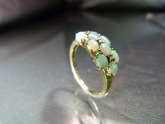 9ct Gold Opal and Diamond Ring. 10 oval opals interspersed with 7 small diamonds in an approx 7.