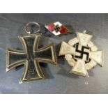 Two Nazi Iron crosses (one Hiltler youth) and a swastika badge.