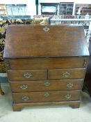 Oak bureau with drawers under and brass handles. Inside is a hidden sliding compartment along with